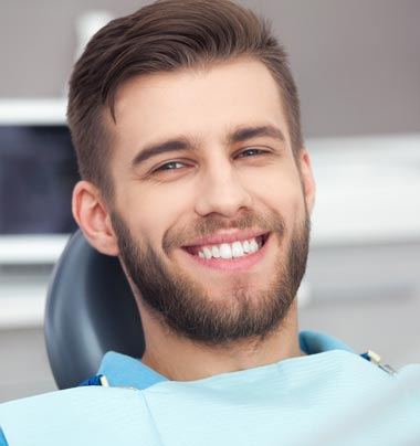 man sitting in dental chair smiling