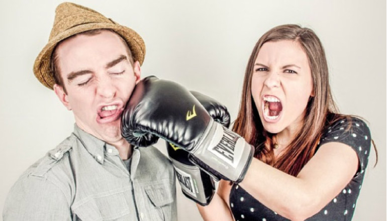 woman punching man in the jaw with boxing gloves creating a dental emergency