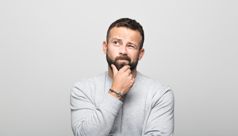 Brunette man strokes his chin as he ponders experimenting with a dental fad