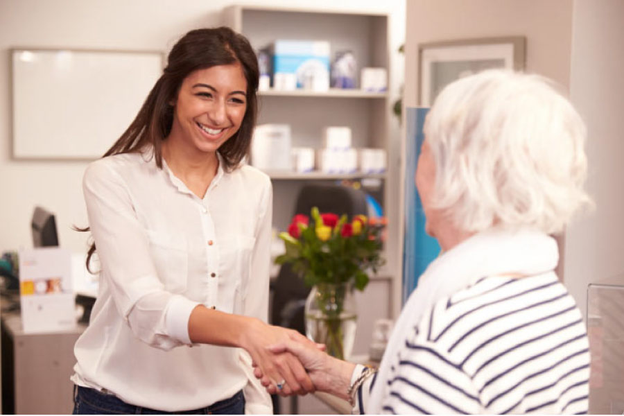 dental assistant welcomes a patient to the office