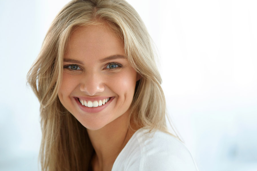 young woman smiles to show off her white smile