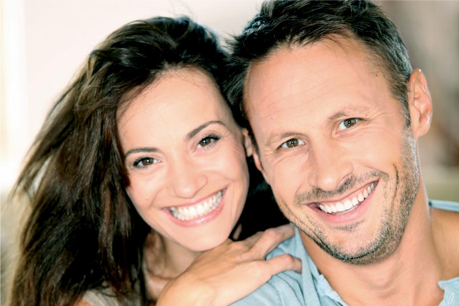 young couple smile showing off their porcelain veneers