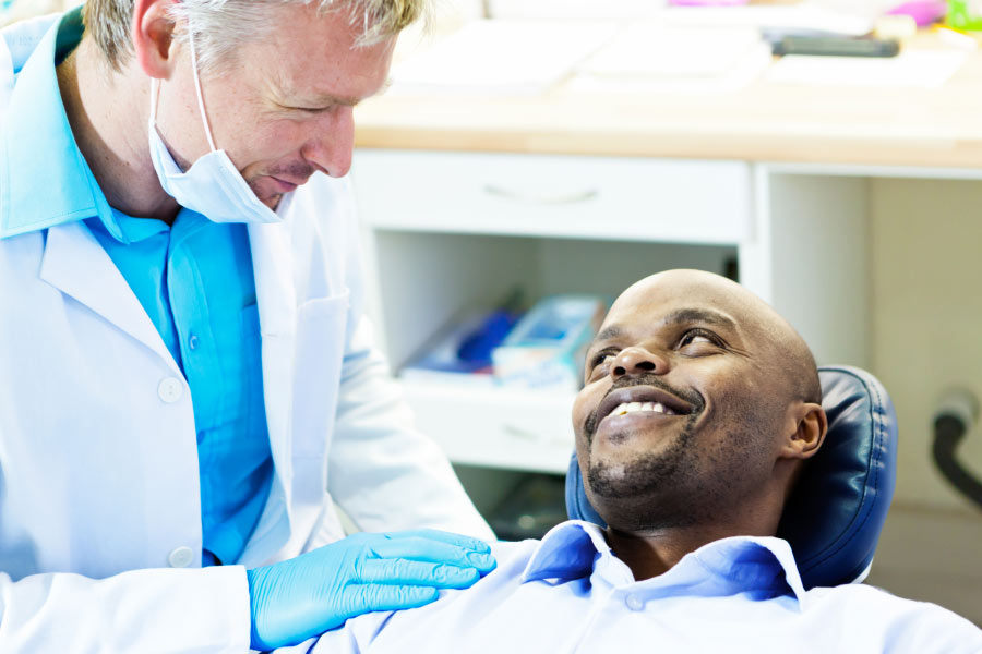 man sitting in the dentist chair discusses gum health with the dentist