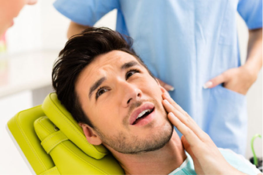 man holding his cheek gets ready for root canal therapy