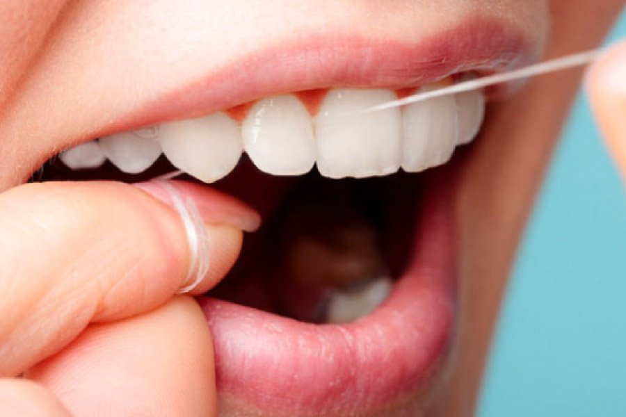 close up of flossing a set of white teeth