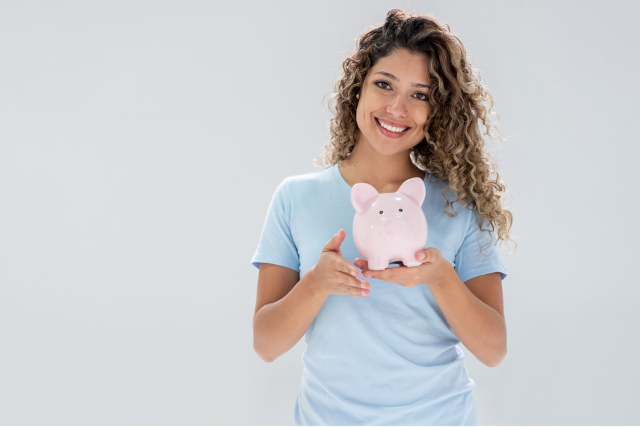 woman holds up a pink piggybank